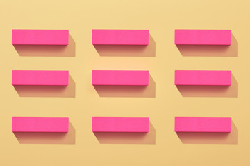A lot of pink nail buffer block on yellow background. Colorful pattern. Art concept. Art direction....