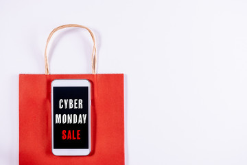 Cyber Monday concept. Mobile phone or smartphone with paper bag on white background. Online shopping, Single's day of China 11.11.