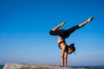 Asian girl practice Yoga on the beach Sunrise morning day
