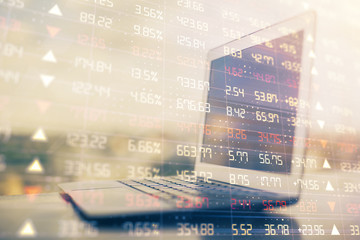 Obraz premium Stock market graph on background with desk and personal computer. Double exposure. Concept of financial analysis.