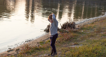 Fototapeta premium Little boy child grabbed his head on the beach because of bad water