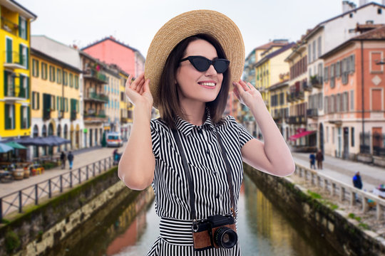 portrait of young beautiful woman tourist walking with camera in italian town