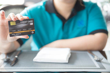 blurred of woman showing credit card in restaurant