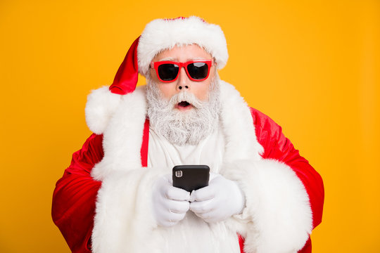 Omg tradition christmas discounts. Close up photo of impressed voiceless funky fat santa claus use smartphone find x-mas sales on internet wear red hat headwear isolated over shine color background