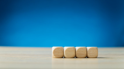 Four blank wooden dices placed in a row