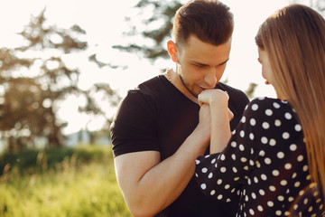 Cute couple in a park. Lady in a black dress. Guy in a black t-shirt.