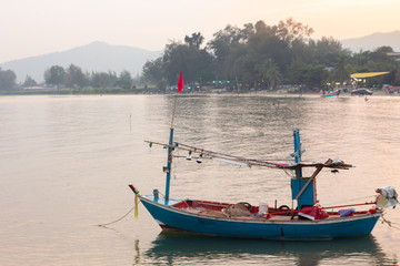 Fishing boat parked at the sea on the coast of Hua Hin in the evening