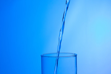 LLenando un vaso de agua, chorro de agua que se introduce en el interior de un vaso