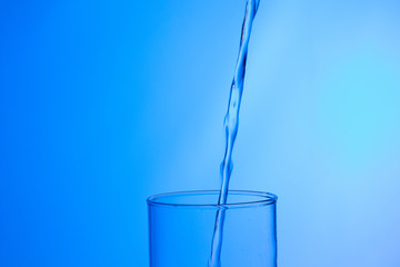 LLenando un vaso de agua, chorro de agua que se introduce en el interior de un vaso