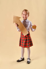 Little cute kid baby girl 6-7 years old.yellow background. Kids childhood lifestyle.concept of business, success and money. Appreciation of exchange rates. Gold bank card, gold arrow up.Copy space.