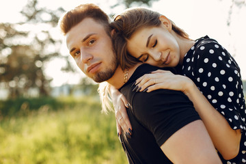 Cute couple in a park. Lady in a black dress. Guy in a black t-shirt.