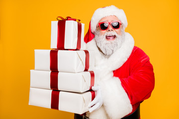 Portrait of funny funky grey hair santa claus in red hat hold packages he brings for good kids...