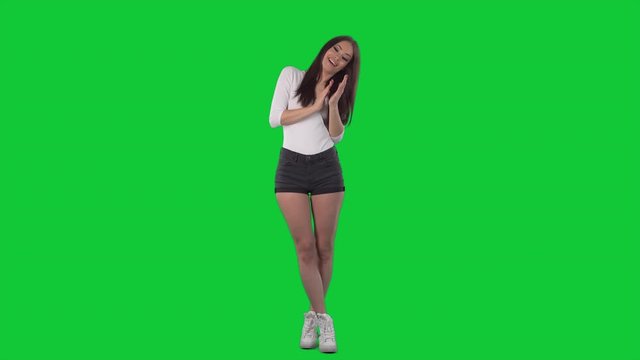 Cheerful excited young beautiful woman clapping hands applauding and celebrating.  Full body isolated on green screen chroma key background	