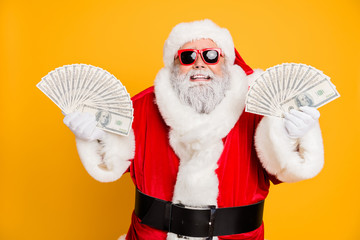 Credit bank x-mas lottery win. Funny funky white bearded santa claus hold double money jackpot fan become north-pole millionaire wear red hat headwear isolated over yellow color background
