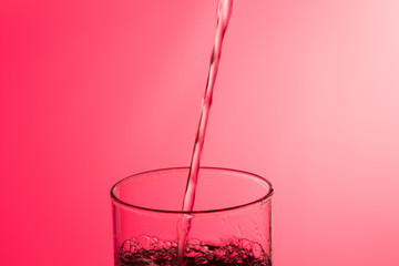 LLenando un vaso de agua, chorro de agua que se introduce en el interior de un vaso