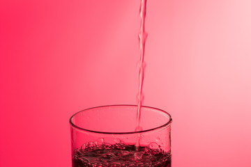 LLenando un vaso de agua, chorro de agua que se introduce en el interior de un vaso