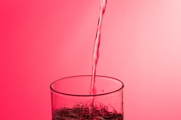 LLenando un vaso de agua, chorro de agua que se introduce en el interior de un vaso