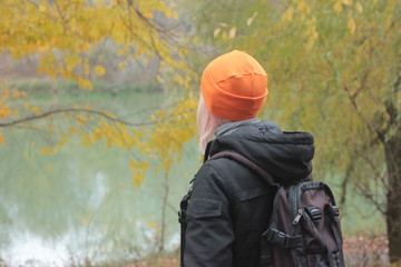 young woman in bright hat on beach in the autumn park