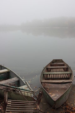 Fishing old boats on the river bank in the fog
