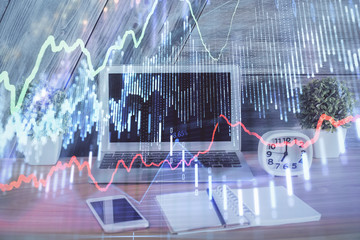 Double exposure of chart and financial info and work space with computer background. Concept of international online trading.