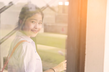 Portrait of asian student in white uniform are looking the camera. Thai student are smiling at camera with walking on the stair in the school.