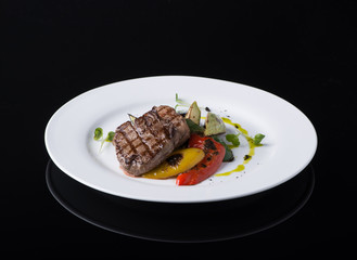dish of fried meat in a plate on a black background