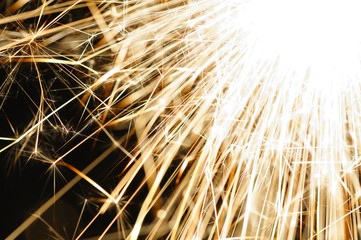 Obraz premium Close-up of golden sparkles of a burning fire