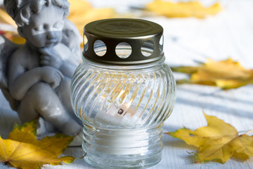Angel and burning candle, leaves, white background