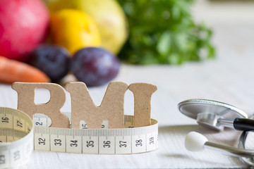 Body mass index BMI with measuring tape, stethoscope and fruits concept - obrazy, fototapety, plakaty