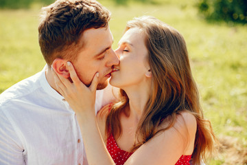 Couple in a field. Girl in a red dress. Man in a white shirt