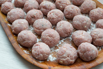 Delicious raw meatballs on a wooden tray