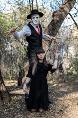 A masked puppeteer controlling and manipulating a girl. Girl portrays puppet. The concept of...