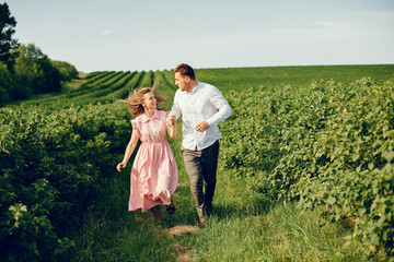 Couple in a field. Girl in a pink dress. Man in a white shirt