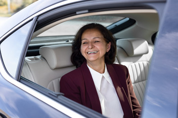Beautiful senior businesswoman is driving in the car