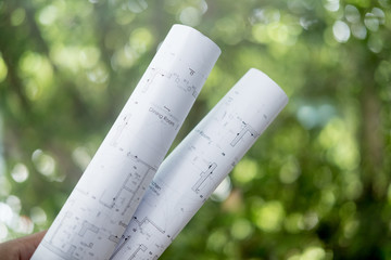 Male architect or civil engineer hand holding rolled blueprints © Dontree