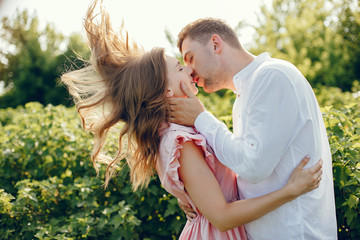 Couple in a field. Girl in a pink dress. Man in a white shirt