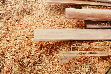the stack of hard plank wood on sawdust background