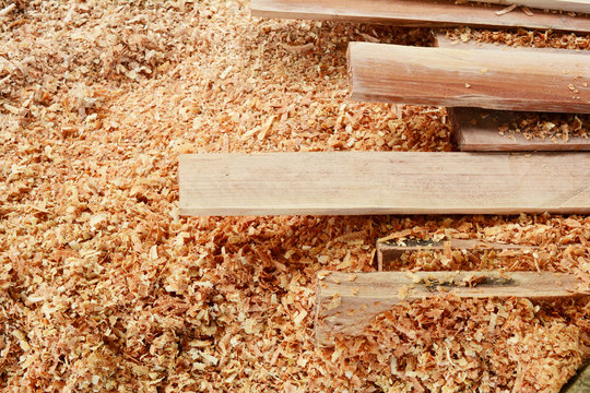 the stack of hard plank wood on sawdust background