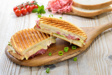 Getoastetes und im Kontaktgrill gepresstes italienisches Panini mit Serrano Salami, Käse , Tomaten...