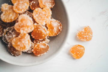 Homemade orange jelly beans heart shaped in the plate. View from above
