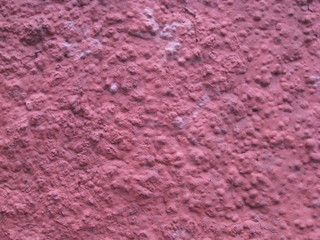 fondo. Muro pintado en rosa fuerte con textura gotelet gruesa de grano y burbujas con granos decapitados haciendo efecto cráter y cambio textura