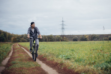 Obraz premium A man on a bicycle in the autumn on a field road