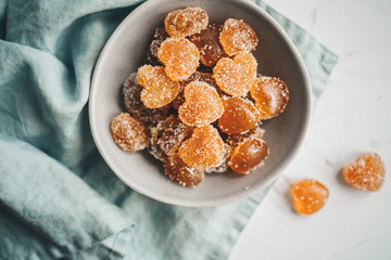 Homemade orange jelly beans heart shaped in the plate. View from above
