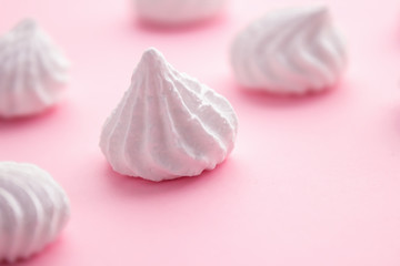 White meringue cookies on pink pastel background