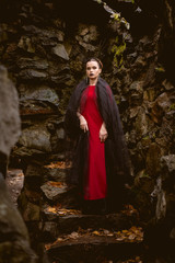 woman witch in red dress in a medieval castle.The medieval queen.  Evil witch