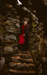 Fototapeta na wymiar woman witch in red dress in a medieval castle.The medieval queen. Evil witch