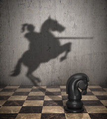 The concept of the hidden potencial. A chess knight that throws the shadow of a knight on a horse. 3D illustration © MYKHAILO