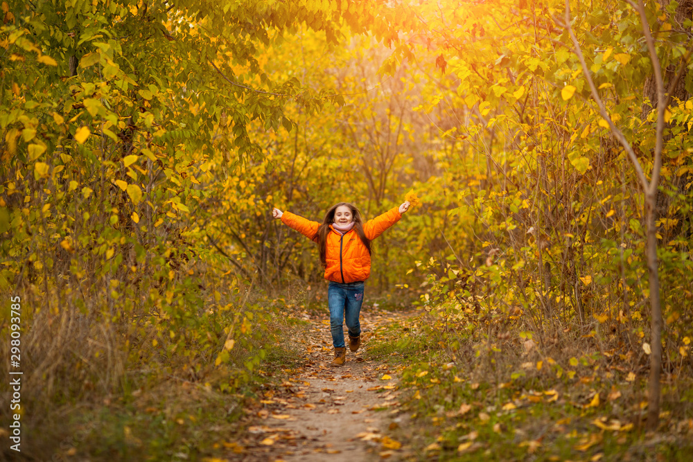 Wall mural adorable happy little girl with autumn leaves