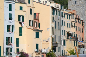 Fototapeta na wymiar Typical Ligurian houses in the village of Portovenere. In the background a tower belonging to the walls of the fort.