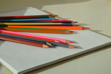 color pencils and notebook on white background